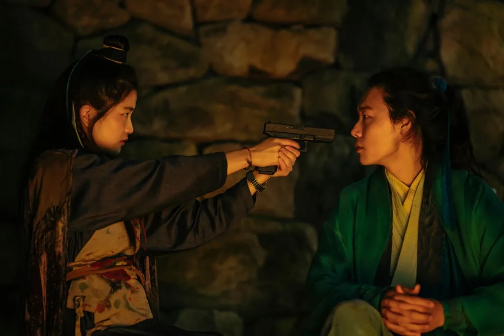 Kim Tae-ri pisztolyt fog Ryu Junra Az Alienoid 2.: Visszatérés a jövőbe című filmben